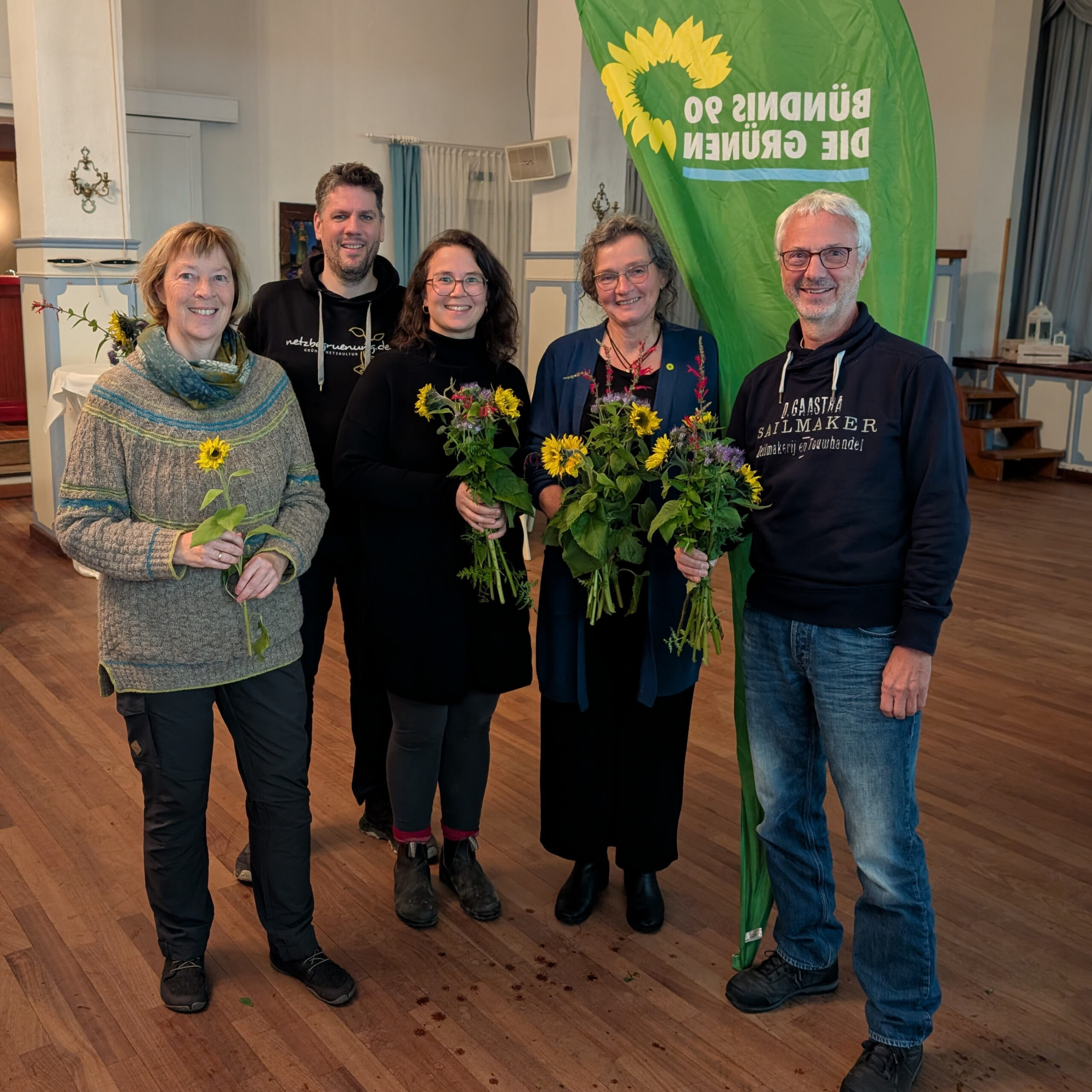 Jutta Greve, Norbert Tretkowski, Klaudia Schumann, Silke Sörensen und Rüdiger Bergmann vor einer grünen Beachflag.